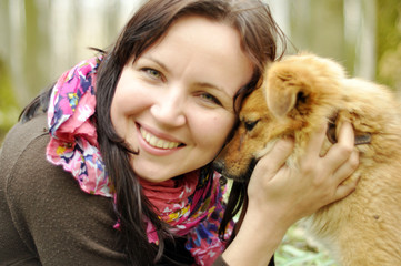 Attractive young girl with a puppy outdoors