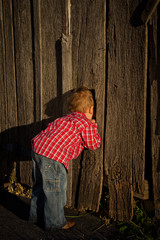 Young Boy Peeking in a Barn