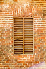 Fototapeta na wymiar Old Wood Slat Window in Brick Wall