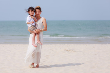 Fototapeta na wymiar Woman and son walking on beach