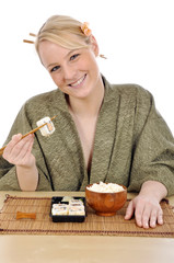 Junge Frau im Kimono isst Sushi mit Stäbchen