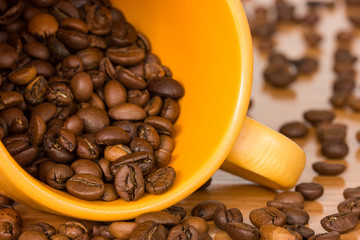 Yellow cup with many coffee beans
