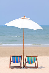 Beach chairs and white umbrella
