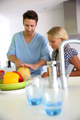 Man with young girl preparing meal in kitchen