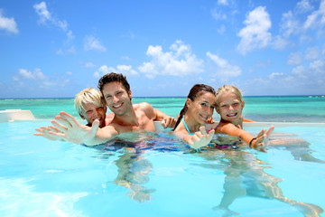 Family of four bathing in swimming pool