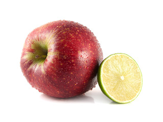 Isolated red apple with half of lime on a white