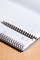 Close up shot of pen lying on the open notebook