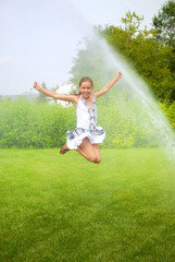 Fototapeta na wymiar Girl jumps under spray drops