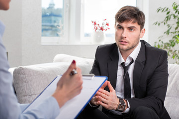 Oppressed man talking with psychologist