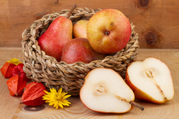fresh pears in basket on wooden background