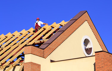 Carpenter man working on the new roof © SasaStock