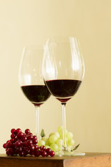 Dos copas de vino tinto con uvas rojas y verde aisladas.