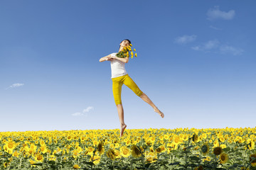 Girl jump over yellow flowers