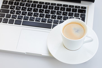 Cup of coffee  on a laptop keyboard