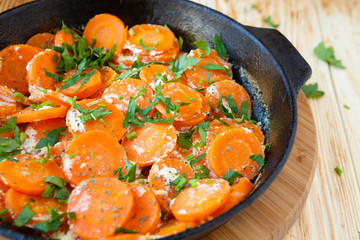 carrots and sour cream in a frying pan with herbs