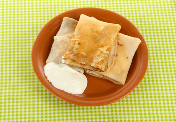 Pancakes with cottage cheese on plate on checkered background