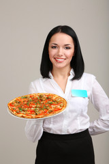 Beautiful girl waiter with pizza isolated on white