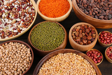 Different kinds of beans in bowls on  table close-up