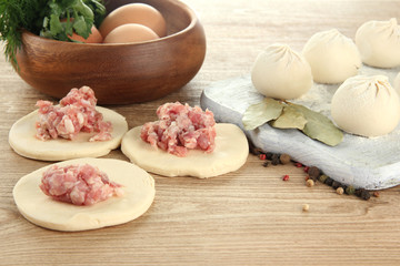 Raw dumplings, ingredients and dough, on wooden table