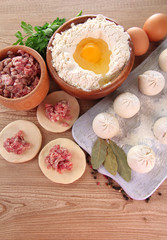 Raw dumplings, ingredients and dough, on wooden table