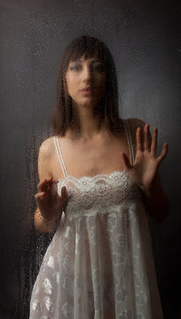 The brunette for a wet glass on a black background.
