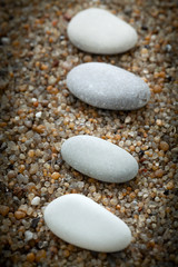 Fototapeta na wymiar Stones lie on coarse sand