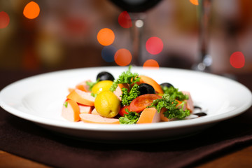 Tasty salad on dark background with bokeh  defocused lights