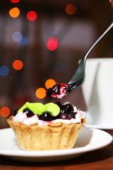 Tasty blackberry cake and cup of beverage,