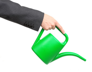 Hand of a businessman pouring water from watering can isolated