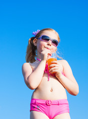 little girl drinks orange juice