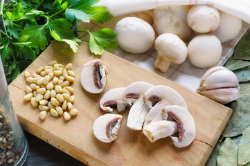 Cut and whole white champignon mushrooms, with garlic, parsley, pepper, pine nuts and laurel