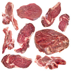 Collection of raw beef steaks and lamb chops over white