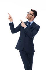 Smiling young businessman pointing at copy space.