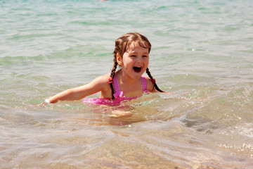 Little girl swimming in the sea. Summer holidays.