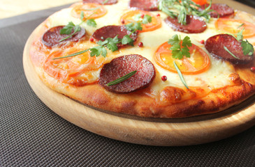 Pizza with tomato, salami and herbs