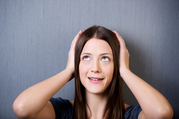 Naklejka premium junge frau schlägt hände über dem kopf zusammen