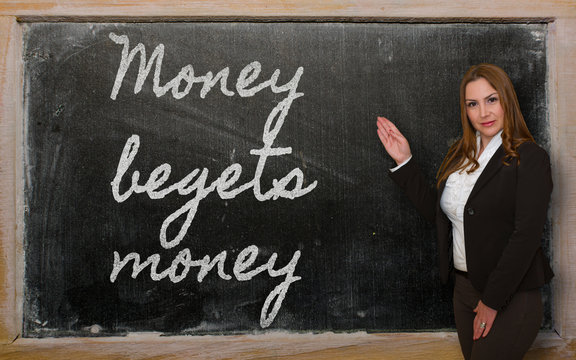 Teacher showing Money begets money on blackboard