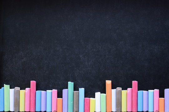 Lavagna con gessi colorati disposti in fila