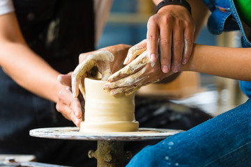 Potter creating clay bowl on turning wheel