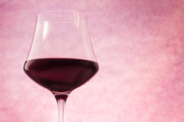 red wine glass over pink background
