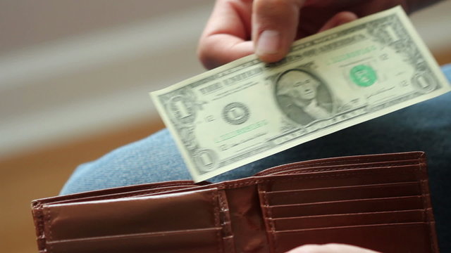 Shrinking dollar, smaller and smaller bills pulled from wallet