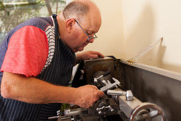 senior man operating lathe machine