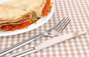 Delicious pancakes with red caviar on table close-up