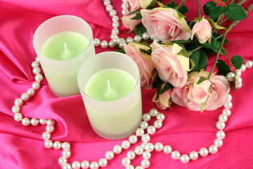 Candle on pink fabric close -up