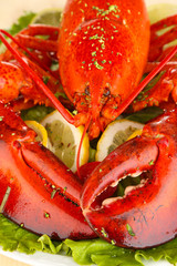 Red lobster on platter with vegetables on wooden table close-up
