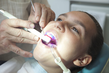 Fototapeta premium Dentist finishing dental examination with ultraviolet light
