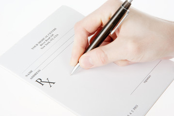 Doctor filling in empty medical prescription isolated