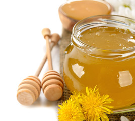 Honey and flowers on a white background