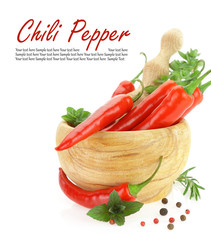 Red hot chili peppers with herbs in wooden mortar