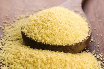 couscous in wooden spoon on kitchen table